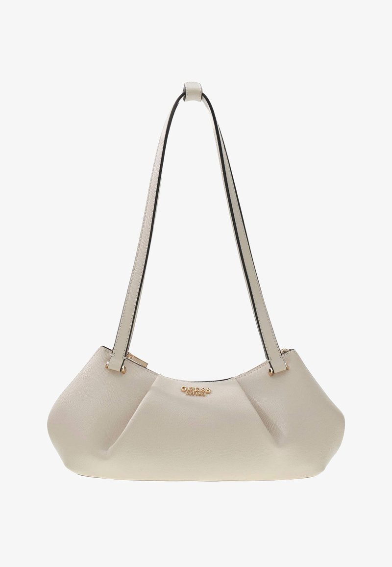 Petit sac à épaule beige avec longues bandoulières, forme arrondie et logo doré "GUESS EST 1981" au centre avant.