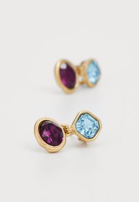 Goldfarbene Ohrringe mit einem lila ovalen Edelstein und einem hellblauen sechseckigen Edelstein, die in einem strukturierten, bezelartigen Design eingefasst sind.