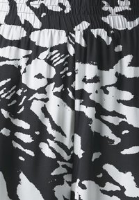 Tela de patrón en blanco y negro con un diseño fluido. Textura suave con una banda elástica en la cintura, que enfatiza el contraste de colores.