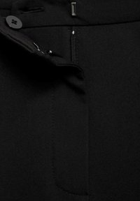 Pantaloni neri realizzati in tessuto liscio, con zip frontale e chiusura a un bottone. Include dettagli delle tasche lungo la vita.