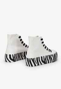 Weisse Canvas-Hochschnitt-Sneaker mit schwarzen Schnürsenkeln und einer gestreiften schwarz-weißen Plattformsohle. Minimalistisches Design mit strukturiertem Finish.