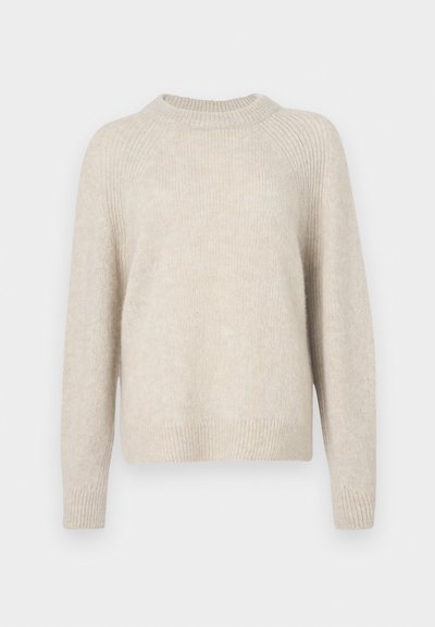 Beige strikkegenser med rund hals, raglanermer og ribbestrikket nederkant. Myk tekstur med en litt løs passform og minimal mønster.