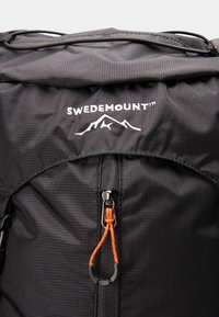 Sac à dos noir avec une poche zippée munie d'un curseur orange, des coutures grises et le logo "SWEDEMOUNT" au-dessus d'un graphique de montagne.