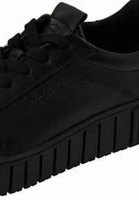 Svarta lädersneakers med en slät yta, utrustade med svarta snören, en vadderad tunga och en tjock, räfflad svart gummisula.