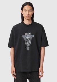 Czarna, oversize koszulka wykonana z bawełny, z detalicznym białym graficznym wzorem o skomplikowanych motywach umieszczonym na przodzie.