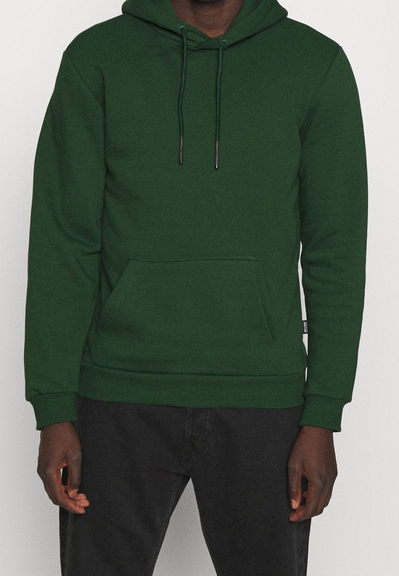 Groene hoodie van zachte stof, voorzien van een kangoeroezak, een capuchon met trekkoord, geribbelde manchetten en een comfortabele, losse pasvorm.
