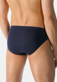 Marinblå simshorts i slät tyg med en tättsittande passform. Har en klassisk midjeresår och sömlös design för komfort och stöd.