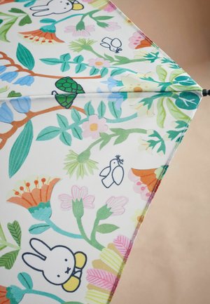 Folded umbrella with a colorful floral pattern. Features green leaves, pink and orange flowers, and cartoon characters on a white background.
