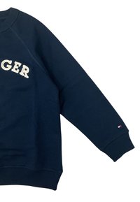 Felpa blu navy con collo a girocollo a coste e maniche raglan. Presenta la scritta ricamata "LONGER" in un colore chiaro e un piccolo logo sulla manica.
