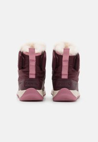 Botte imperméable en bourgogne profond avec une doublure en fausse fourrure blanche confortable, des accents roses et une semelle en caoutchouc texturé. Comprend une languette à l'arrière.