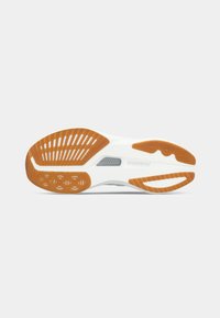 Sole of a Saucony running shoe in white with orange and gray rubber tread patterns on a plain background.