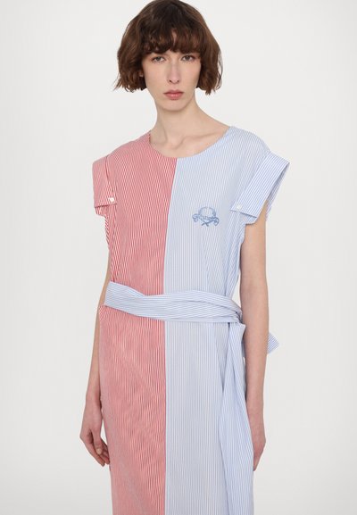 Robe rayée, avec des sections de tissu rouge et bleu. Manches courtes, décolleté rond, avec une ceinture à la taille et un détail brodé sur la section bleue.