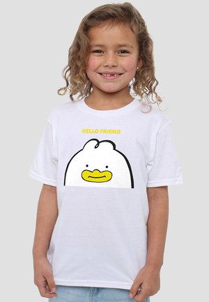 Kind mit lockigem Haar, das lächelt, trägt ein weißes T-Shirt mit einem Cartoon-Hühnergesicht und dem Text "HALLO FREUND" in Gelb.
