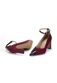 Bordeaux-suede High Heels mit einer spitzen schwarzen Lackspitze und einem Knöchelriemen. Sie verfügen über einen komfortablen Blockabsatz und eine glatte Sohle.