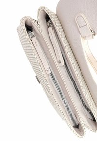Lichtbeige handtas met geweven textuur en gladde leren accenten, drie compartimenten en zilveren rits sluitingen.