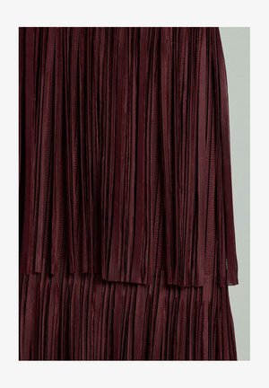 Tessuto bordeaux con frange, caratterizzato da strisce verticali con una texture liscia e un design stratificato che dona un aspetto fluido.