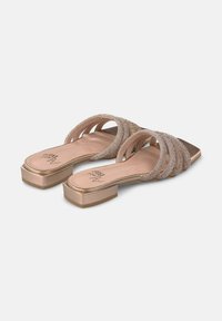 Sandali open-toe con molte cinghie scintillanti. Materiale beige morbido, forma della punta quadrata e un tacco quadrato dorato basso. Dettagli testurizzati presenti.