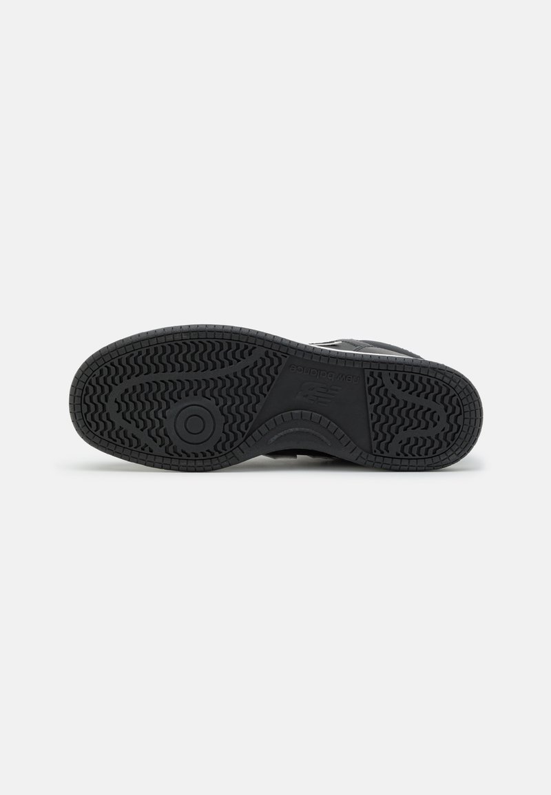 Schwarze Sport Schuhsohle aus strukturiertem Gummi, mit einem kreisförmigen Muster und einzigartigem Profil für Grip und Stabilität.