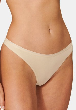 Thong in cotone beige con una texture liscia, design minimalista, lati stretti e una vestibilità a vita bassa, adatto per l'uso quotidiano.