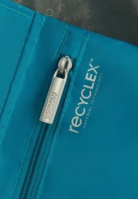 Borse di stoffa turchese con una cerniera argentata etichettata "American Tourister" e il logo "recycleX" in bianco, che mette in mostra una texture liscia.