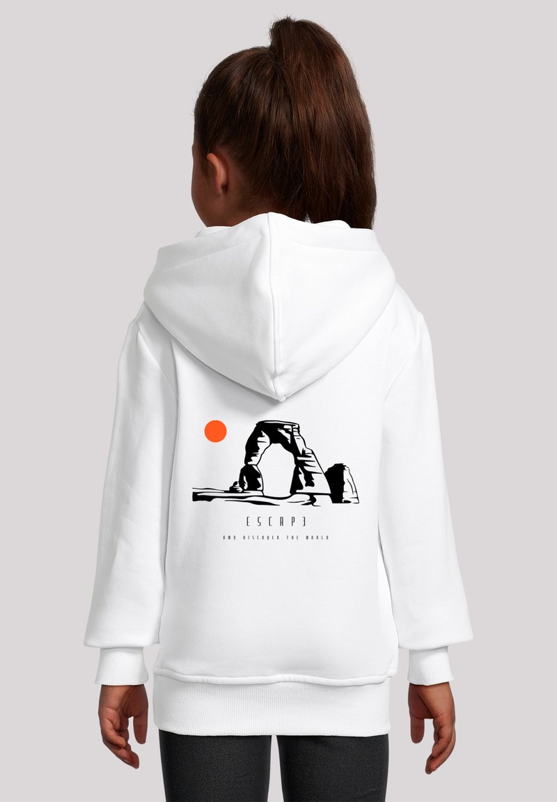 Weiße Kapuzenjacke mit einem Grafikdesign eines Felsvorsprungs und einer orangefarbenen Sonne. Unter dem Design steht der Text: "ENTFLIEHEN UND DIE WELT ENTDECKEN."