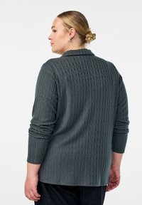 Tamno siva kardigan od pletiva s okovratnikom i dugim rukavima, s teksturiranim uzorkom i opuštenim krojem.