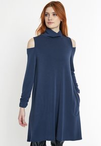 Navy-blaues Cold-Shoulder-Kleid mit hohem Kragen, langen Ärmeln und Seitentaschen, aus weichem, dehnbarem Material gefertigt.
