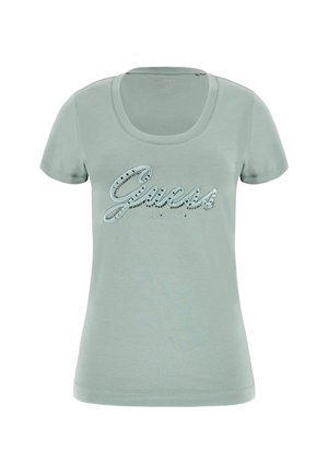 Light green cotton t-shirt with a scoop neck. Features the word "Guess" in shiny lettering and the year "est. 1981" below. Short sleeves.