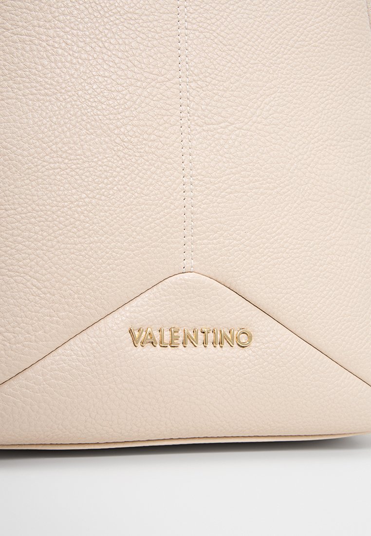 Beige Lederhandtasche mit strukturiertem Oberflächen, goldenem "Valentino"-Logo und einem Chevron-Muster am Boden. Sauber sichtbare Nähte.