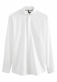 Camisa blanca de manga larga, hecha de un tejido suave, que presenta un cuello tipo banda y una tapeta de botones oculta. Los puños son redondeados con cierres de botón.