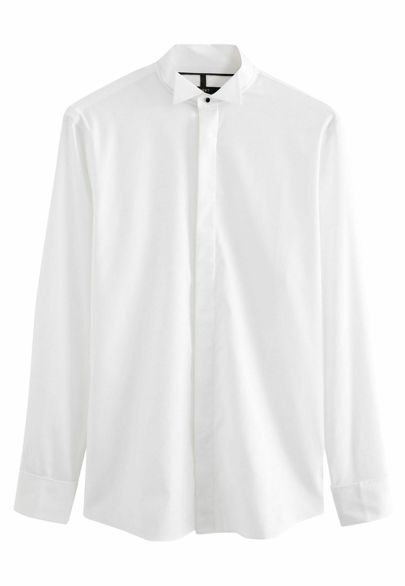 Camisa blanca de manga larga, hecha de un tejido suave, que presenta un cuello tipo banda y una tapeta de botones oculta. Los puños son redondeados con cierres de botón.