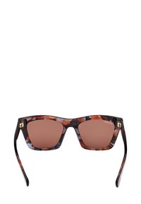 Lunettes de soleil rectangulaires teintées de brun avec des montures à motif écaille de tortue et des branches fines sur fond blanc.