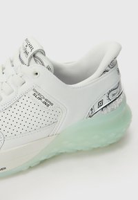 Hvit sneakers med perforert lærøvre, gjennomsiktig mintgrønn såle og sølvfargede paisley-mønstrede detaljer på hælen og tungen.