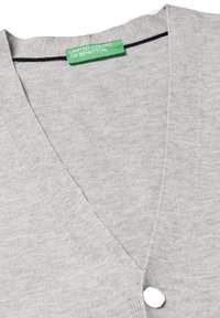 Grauer Cardigan mit V-Ausschnitt, aus weichem Stoff gefertigt. Verfügt über einen einzelnen weißen Knopf und ein grünes Etikett mit dem eingeprägten Schriftzug "United Colors of Benetton".