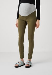 Pantalones de maternidad en verde oliva, con un panel de jersey gris para mayor comodidad. Combinados con sandalias azul claro, que presentan detalles de hebilla.