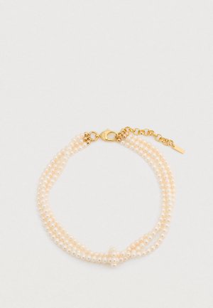 Trois rangs de petites perles blanc cassé avec un fermoir mousqueton en or et une chaîne d'extension, présentant une finition texturée et une forme arrondie.