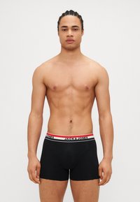 Boxer-briefs en coton noir avec une ceinture élastique ornée d'une bande rouge et blanche et du logo "JACK & JONES". Design à coupe régulière.
