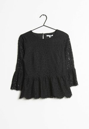 Schwarzes Spitzenoberteil mit runder Ausschnitt, dreiviertellangen Glockenärmeln und einem Peplum-Saum. Verziert mit filigranen Blumenmustern und einem gewellten Rand.