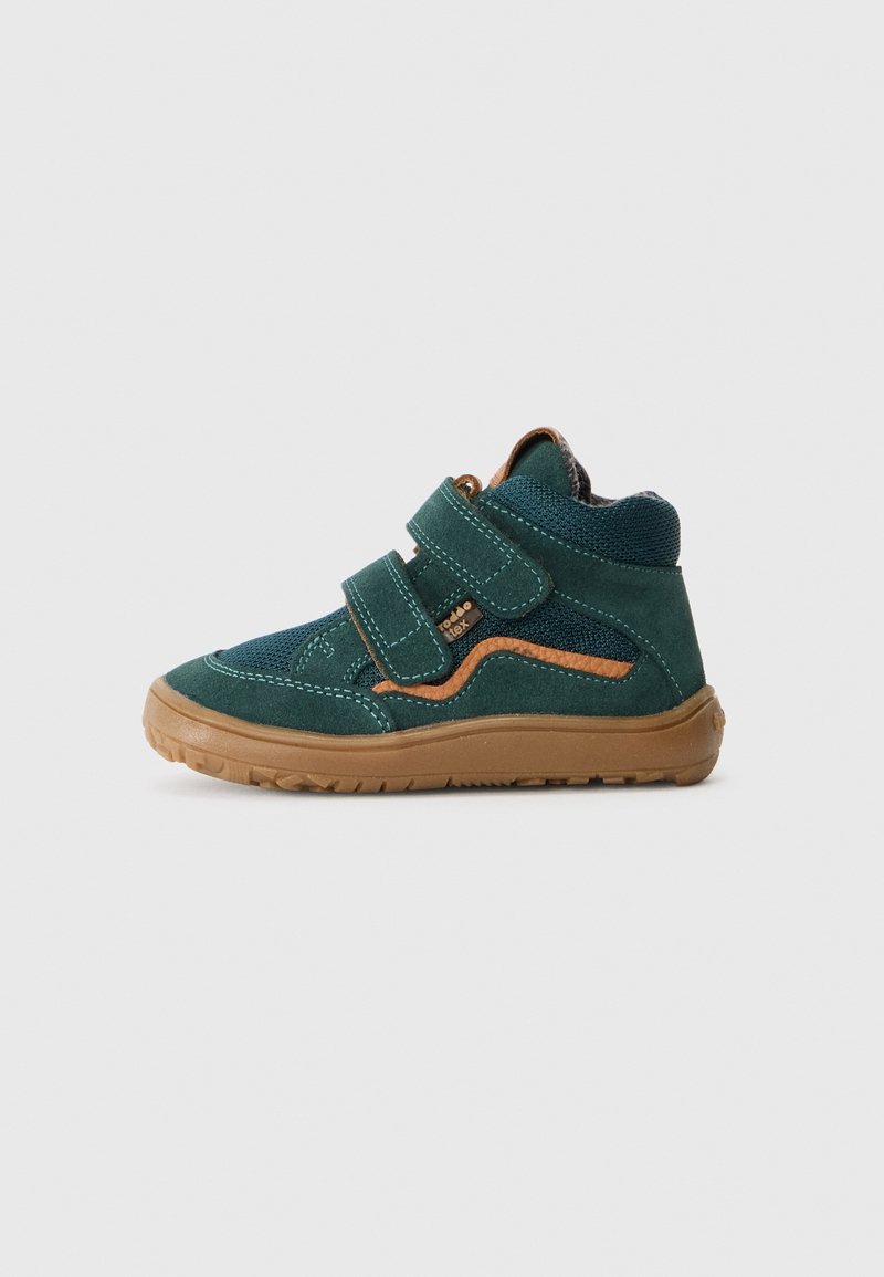 Baskets montantes vert foncé pour enfant avec semelle marron, deux bandes velcro et accent orange sur fond uni clair.