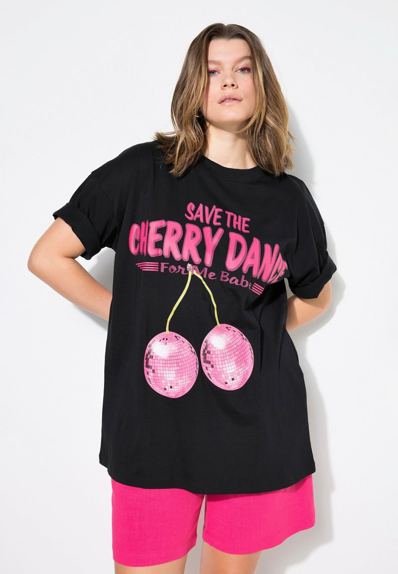 Černé oversized tričko s ohrnutými rukávy. Obsahuje výrazný růžový text "SAVE THE CHERRY DANCE" a grafiku dvou růžových diskotékových koulí.