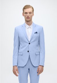 Helles blaues Anzug mit zwei Knöpfen, Reverskragen und einer Brusttasche. Getragen über einem weißen Hemd. Glatte Textur, taillierte Passform, minimalistisches Design.