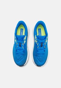 Blauwe hardloopschoenen met een bovenwerk van mesh, groene accenten en een witte zool. Voorzien van platte veters en een gewatteerde tong voor comfort.