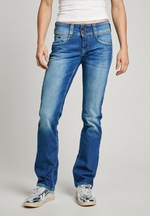 Blå denim jeans med lige ben, let falmning, knaplukning og to forlommer; parret med sølvfarvede sneakers.