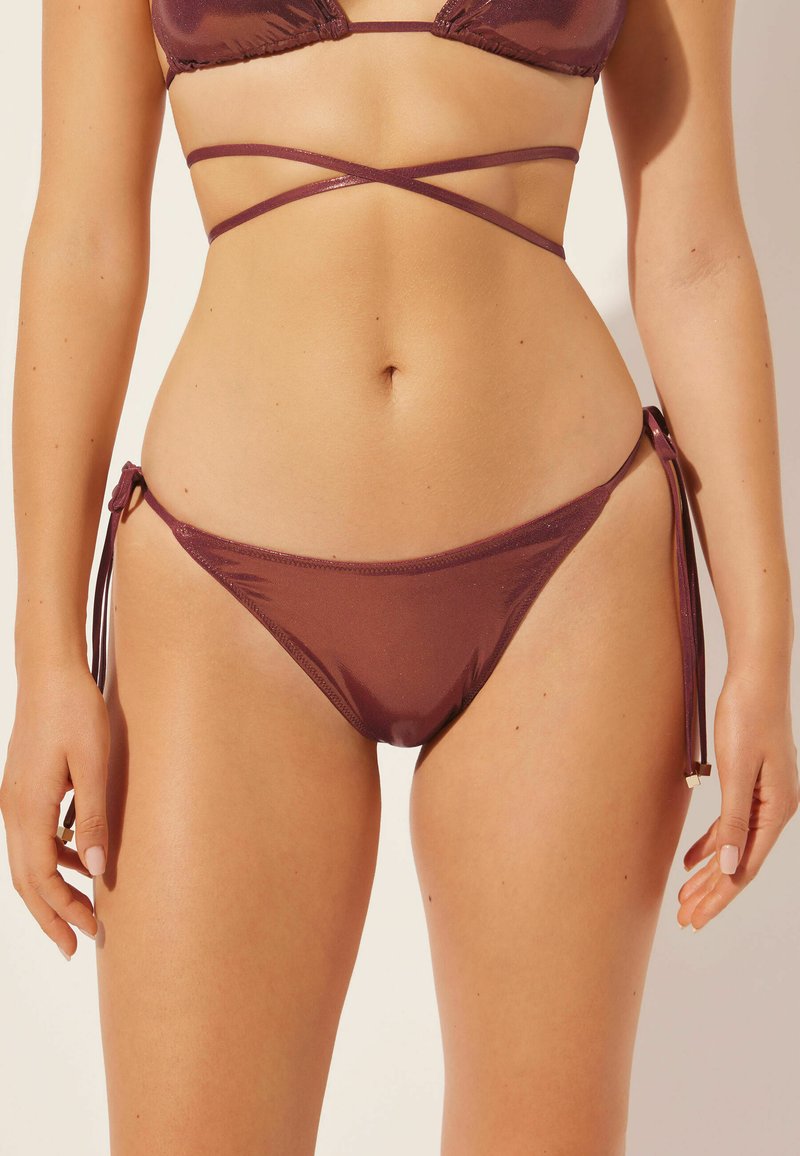 Ensemble de bikini deux pièces de couleur bordeaux profond. Le haut a un design triangulaire avec des bretelles croisées, tandis que le bas présente des côtés à lacer.