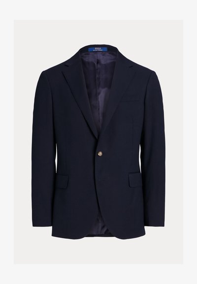 Blazer azul-marinho feito de um tecido com uma textura subtil, apresentando dois bolsos frontais, um bolso no peito e um fecho com um único botão dourado.