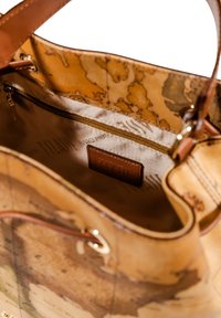 Borsa in pelle color cuoio con motivo mappa del mondo, dotata di interno beige, tasca con zip e etichetta in pelle impresso con il nome del marchio.