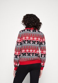 Strickpullover mit festlichem Muster, das Schneemänner, Schneeflocken und Bäume in Rot, Schwarz, Grün und Weiß zeigt. Rippbündchen und Saum.