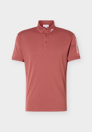 Polo manches courtes couleur rose poussière avec trois boutons, logo J.Lindeberg sur le col et la manche droite.
