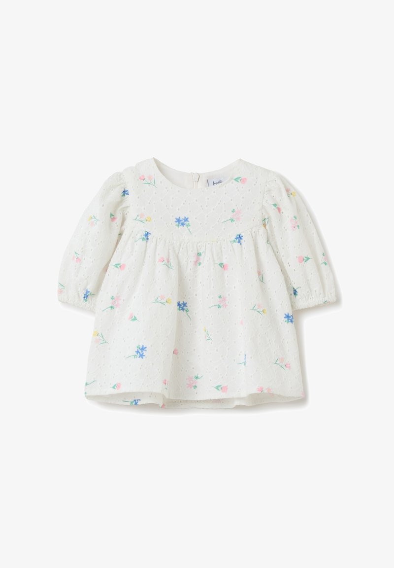 Blusa bianca per bambini con maniche a sbuffo, stampa floreale nei toni del rosa e blu, tessuto strutturato, scollatura rotonda e chiusura con zip sul retro.