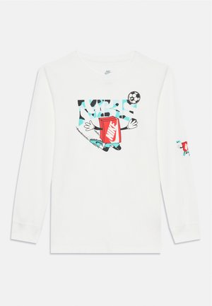 White long-sleeve shirt featuring a colorful graphic with a cartoon character holding a red product and a soccer ball design.
